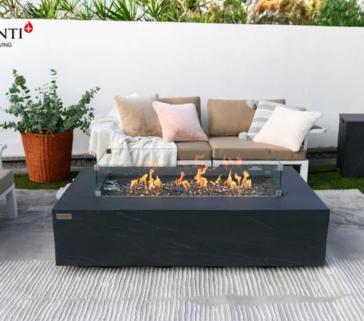 rectangle fire pit table dark grey with windshield. fire pit table is lit with brown fire glass