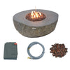 A large, round fire pit bowl made of textured gray material with a visible flame burning in the center. A gray protective cover, a coiled gas hose, and a pile of red lava rocks are shown separately below.