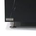 A detailed view of the corner of a black marble porcelain table. The "ELEMENTI THE ART OF LIVING" logo is visible on a small plaque. The table rests on a short, cylindrical, silver leg with a wider, flat base.