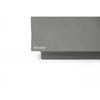 A detailed view of the corner of a grey concrete coffee table, showing the Elementi brand plaque.