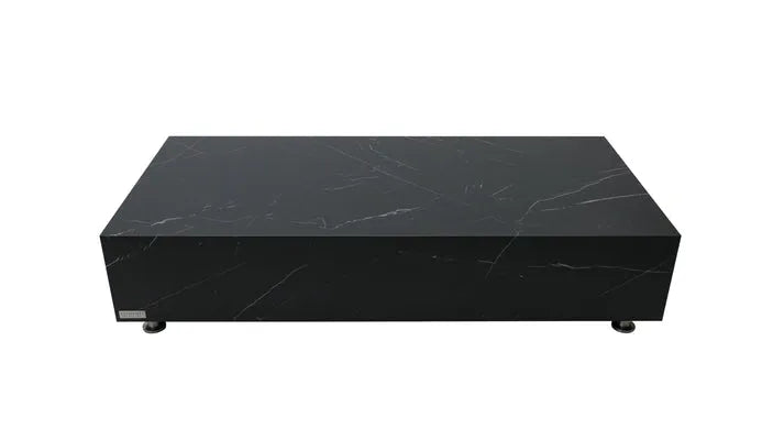 A square coffee table with a dark black marble porcelain top featuring white veining, and a black block base with small, round silver feet.