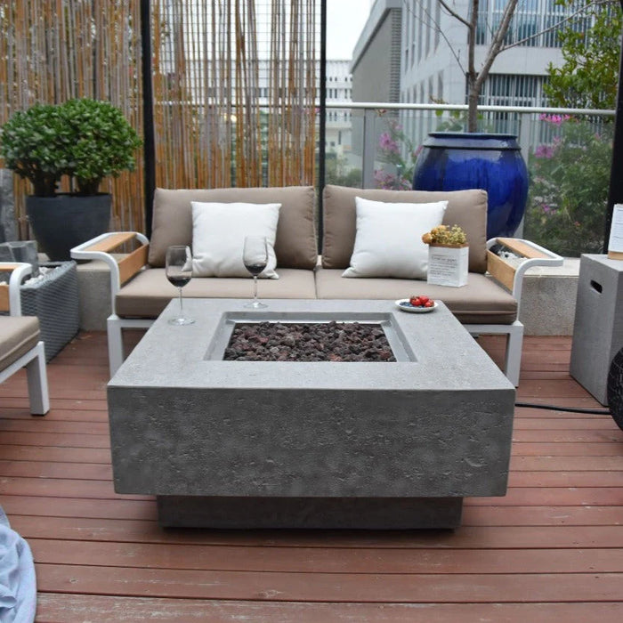 square fire pit table with wine glass and plat on the side of fire table in deck