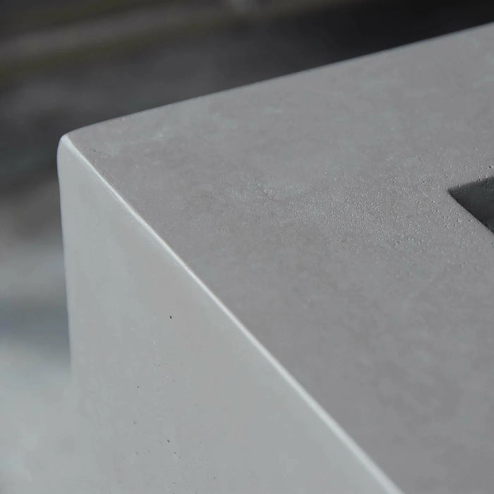 square fire pit table with straight edges on cast concrete close up view