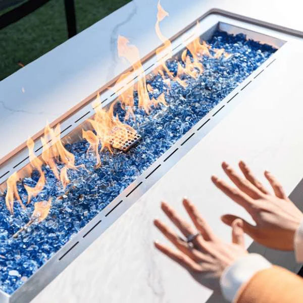 rectangular fire pit lit with lady warming up her hands