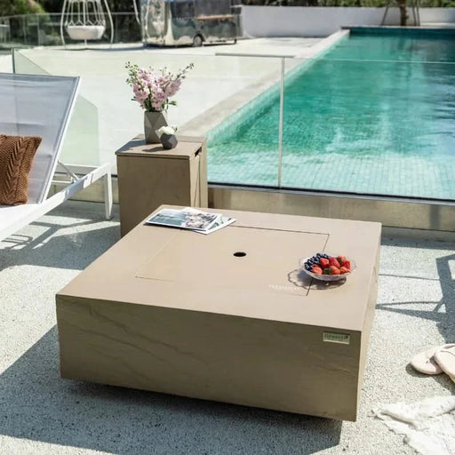 square fire pit table with fire pit lid and fruit platter and newspaper laid on top of fire table 