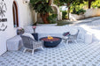 Outdoor patio with seating area, fire pit, and decorative tiles.