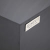 Silver Elementi logo plaque with the phrase "THE ART OF LIVING" on a dark gray concrete surface.