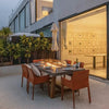 outdoor dining set with fire pit table in backyard. table is set with dining set and chairs