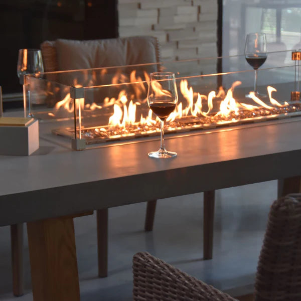 win glass on rectangular out door dinning table with fire pit in the middle