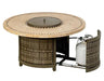 A round outdoor fire table with a woven base and a travertine stone tabletop. The table has a circular burner and blue flames are visible. There is a propane tank storage compartment at the base, and the table has four small wheels.