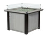  A square fire pit table with a glass top and a glass wind screen. The table is made of gray and black poly lumber and has a flame inside.