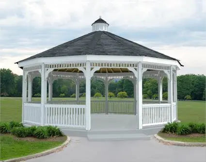 A large, octagonal gazebo with a cupola, surrounded by a wooden railing and a lush green lawn.