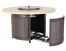 A round outdoor fire table with a woven wicker base and a travertine top. The table has a pull-out drawer for storing propane tanks.