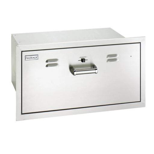 A stainless steel warming drawer with a sleek, modern design. The drawer has a silver handle and the Fire Magic logo is visible on the front.