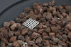 Detail of lava rocks with a square metal grate with holes, positioned among the rocks.