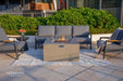 Outdoor patio setup with grey fire pit table, chairs, and Elementi branding.