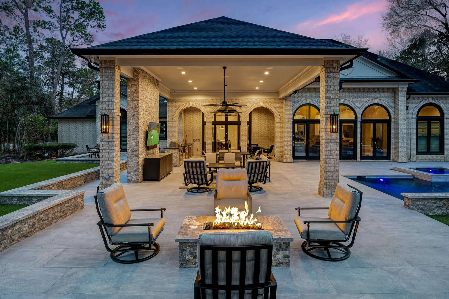 square fire pit next to gazebos in backyard 