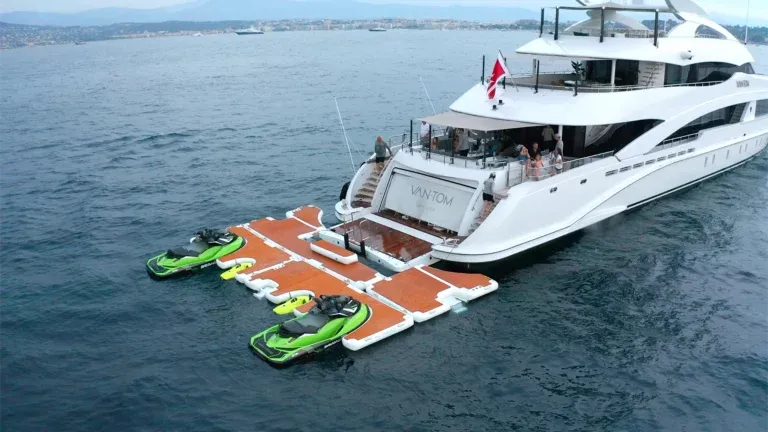 Luxury yacht with water toys amnd jet ski dock on a dock in a body of water