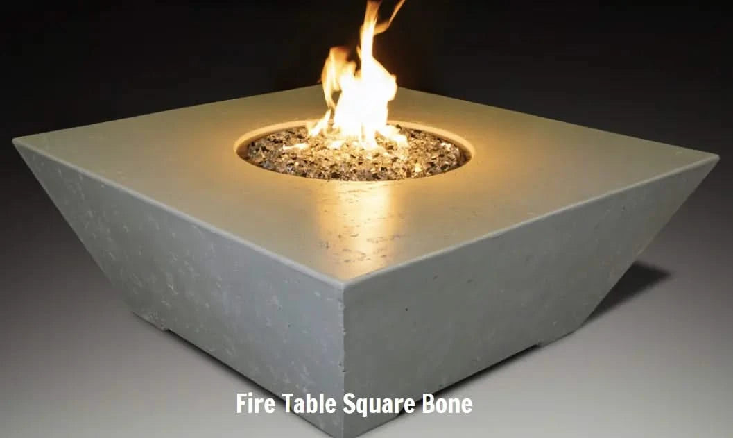 square fire table in bone colour with wide sides with round fire pit with fire burning on glistening fire glass