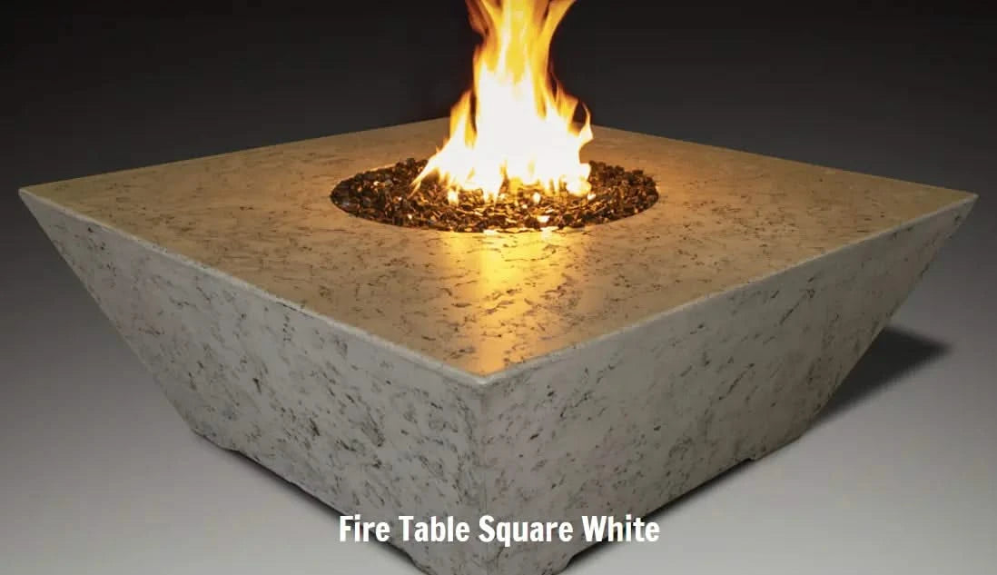 square fire pit table in white concrete and marble material by grand canyon burning on a round fire pit blowing yellow and orange flames