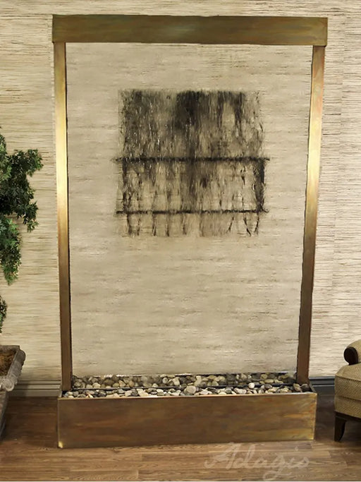 
A tall, elegant Adagio Grandeur River Centered In Base water feature with an Antique Bronze frame and a clear glass water panel. The water cascades down the glass, creating a rectangular pattern of darker, textured flow in the upper middle section. 
