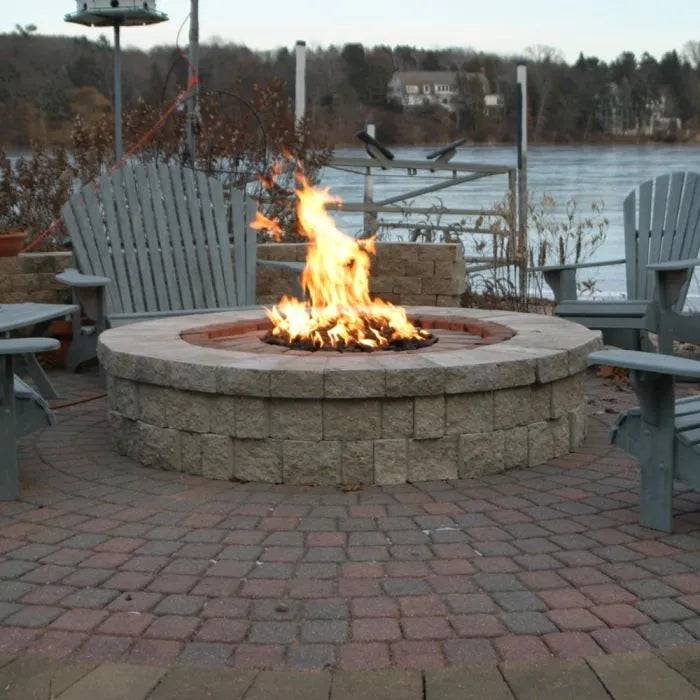 A complete HPC round fire pit enclosure kit with gas tank storage. The kit includes a stainless steel fire pit, a black enclosure with a hinged lid, and a black propane tank hidden inside the enclosure.