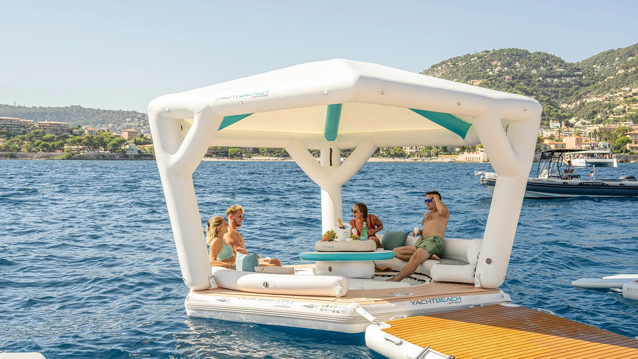 Inflatable float with canopy on a body of water with people enjoying the outdoors.