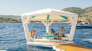 Inflatable float with canopy on a body of water with people enjoying the outdoors.