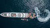 Aerial view of a large yacht with smaller boats on a dark blue ocean.
