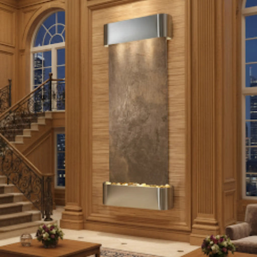 Decorative in door wall fountain by adagio in a luxurious interior setting with wooden paneling and staircase.