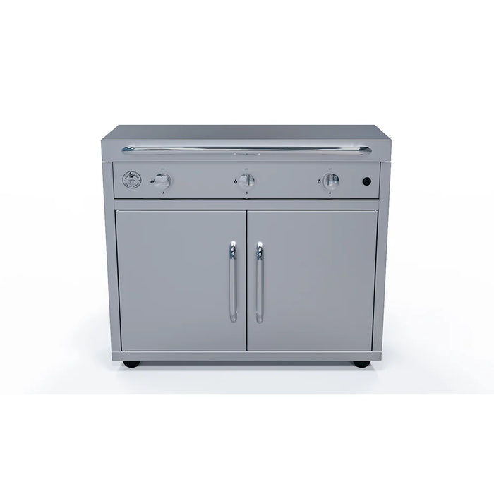 A stainless steel outdoor kitchen cart with two doors and a built-in griddle on top. The griddle has three burners and control knobs.