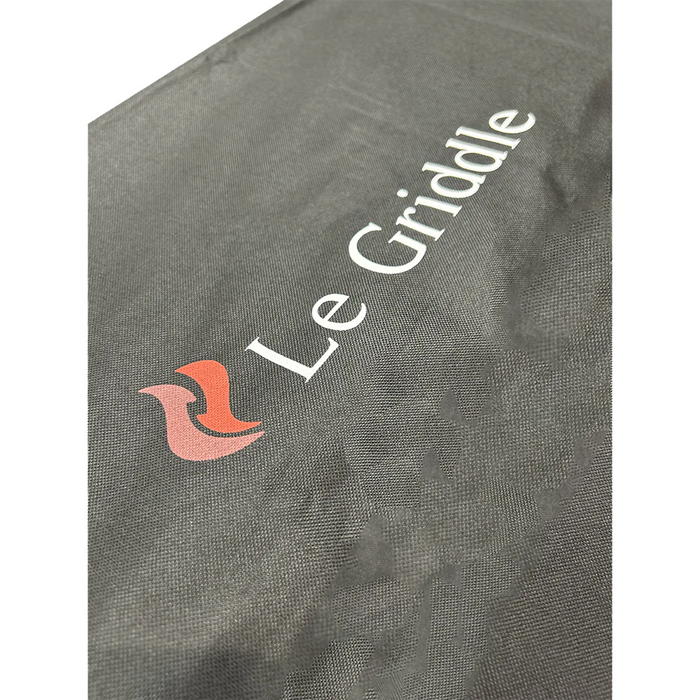 A close-up of a gray nylon grill cover with the "Le Griddle" logo embroidered on it in white.