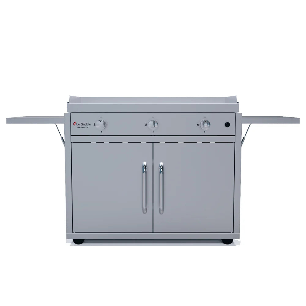 A Le Griddle gas griddle featuring a large cooking surface, two burners, a center handle, and a cabinet with two doors for storage.