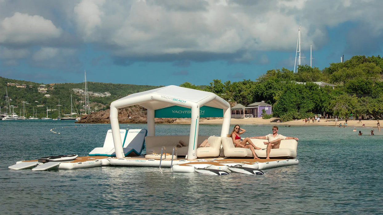 Floating platform with canopy on water, people sitting, and scenic background