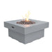 light grey round fire pit table with fire pit lit on lava rocks on a white background