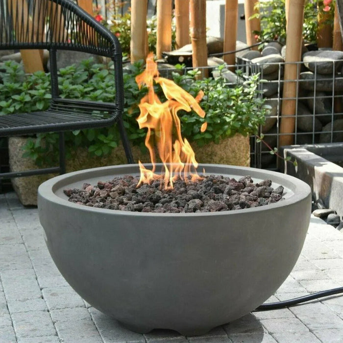 light grey round fire pit bowl burning on lava rocks in outdoor patio