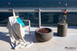 round propane fire bowl with matching tank cover being used as a convenient table top holding vase of flowers, fruit and wine in outside balcony