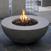 light grey round fire pit bowl is burning on lava rocks in outdoor patio