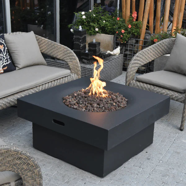 square fire pit table with round fire pit design. round fire pit is lit on lava rocks. fire table is placed in between lounge furniture