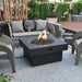 round gas fire pit table is lit on lava rocks on outdoor patio area