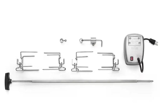 A top-down view of a disassembled Napoleon Commercial Grade Rotisserie Kit. The components are laid out on a white background, including the stainless steel motor, spit rod with handle, meat forks, counterweight assembly, and mounting hardware.