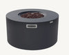 Modern, round fire pit table in dark gray with lava rocks and a rectangular ventilation grill on the side.