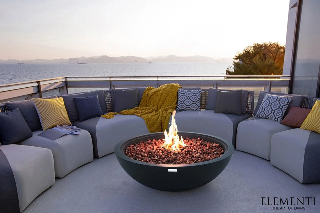 Outdoor seating area with a fire pit on a patio overlooking a scenic view.