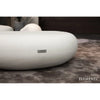 A detailed view of a smooth, cream white Elementi Hawaii Pebble Table, showing its rounded, organic shape and the Elementi logo