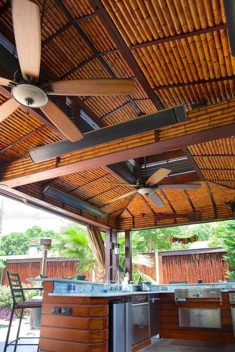 Extend your outdoor living season with this well-equipped outdoor kitchen and bar area complete with patio heaters, a ceiling fan, and a relaxing poolside view.