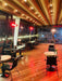 Modern restaurant interior with wooden flooring and string lights with patio heaters on the wall