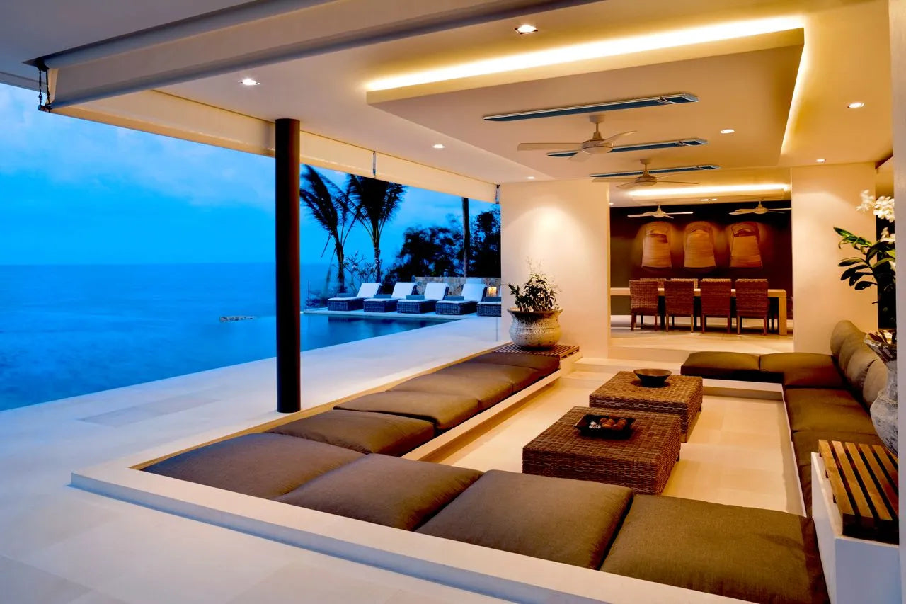 Modern outdoor living area with ocean view, seating, and decorative elements with wall mounted outdoor patio heaters on the wall