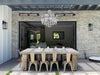 Modern outdoor dining area with a large table and chairs against a brick wall.