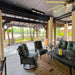 Outdoor patio area with outdoor patio heater, chairs, table, and decorative elements under a covered structure.