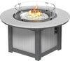 A LuxCraft Lumin 46" Dove Grey Round Fire Pit with a glass wind guard and a fire burning, showcasing white fire glass within.
